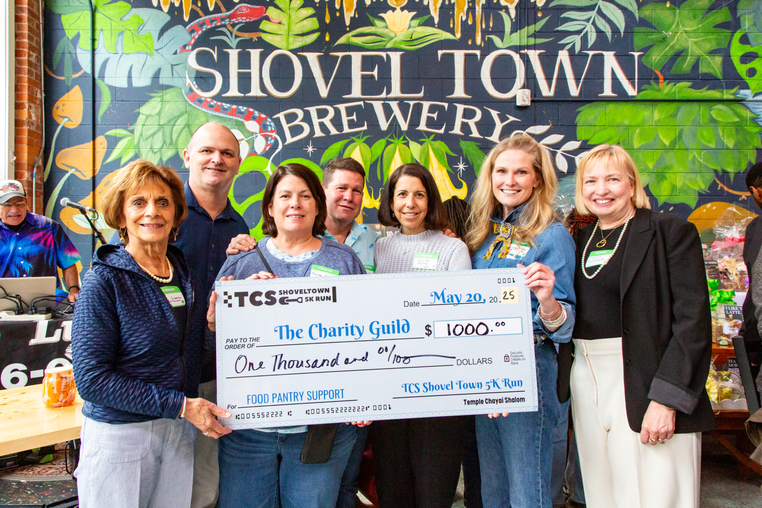 A group of people holding a large check