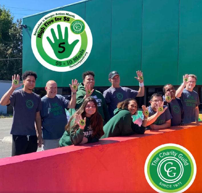 Charity Guild staff high fiving in front of the food pantry